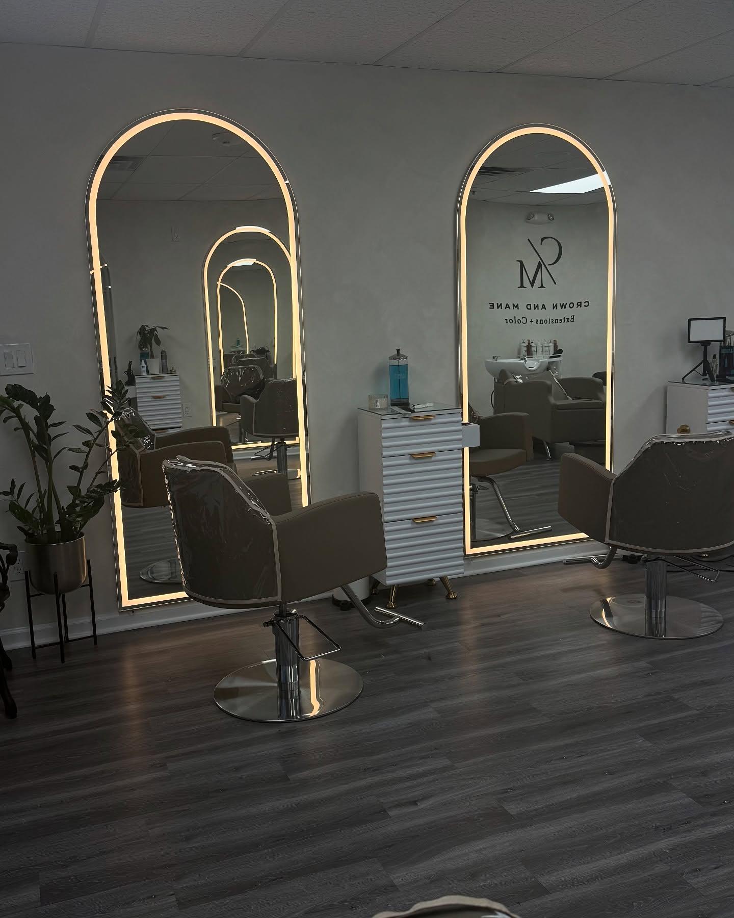 The Crown and Mane studio: arched lit mirrors and styling chairs