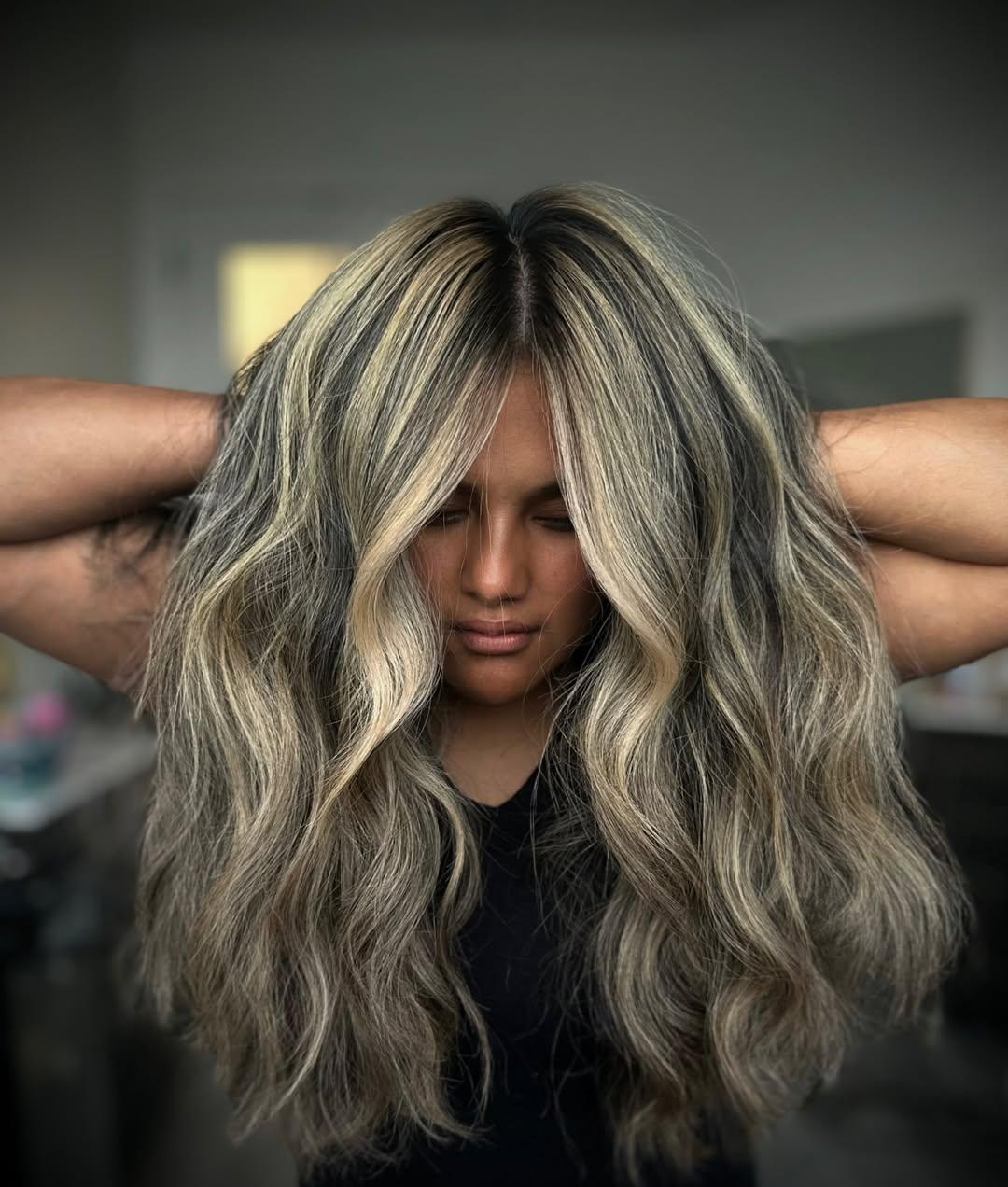 Bright blonde balayage with a soft rooted base, hands lifted through the hair