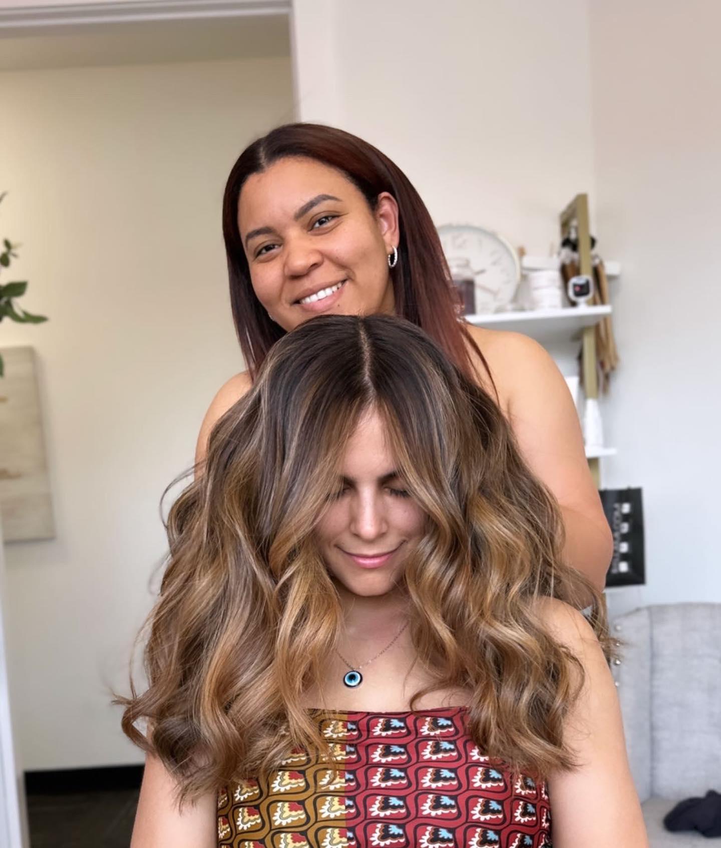 A Crown and Mane stylist with a client after her extension install